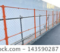 Orange safety netting and temporary enclosure at construction sites 143590287