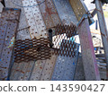 Temporary scaffolding at construction sites: Expanded metal for filling gaps in scaffolding planks and fall prevention safety measures. 143590427