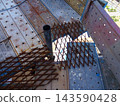 Temporary scaffolding at construction sites: Expanded metal for filling gaps in scaffolding planks and fall prevention safety measures. 143590428