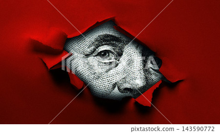 Close-up view of a dollar bill through red torn paper with Benjamin Franklin's face visible Close-up view of a dollar bill through red torn paper with Benjamin Franklin's face visible 143590772