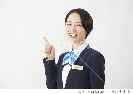 一位中年女員工在白色背景前指向左側。 143591460