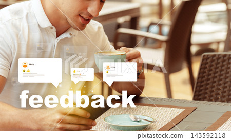 Man sitting in a cafe drinking coffee while looking at feedback on his device Man sitting in a cafe drinking coffee while looking at feedback on his device 143592118