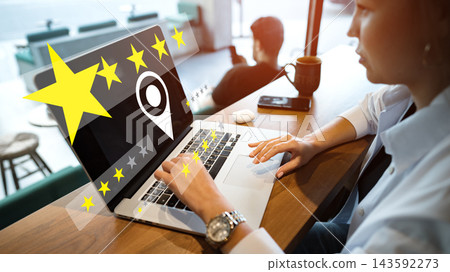 Person using laptop to rate service in cafe during daytime Person using laptop to rate service in cafe during daytime 143592273