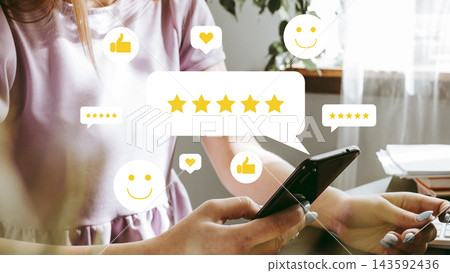 User reviews with five-star rating display on smartphone in a bright room 143592436