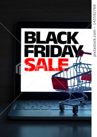 Online shopping during the Black Friday sale with a shopping cart in front of a laptop screen Online shopping during the Black Friday sale with a shopping cart in front of a laptop screen 143592769