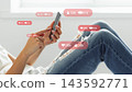 Social media chats and calls taking place on a smartphone in a casual indoor setting during daytime 143592771