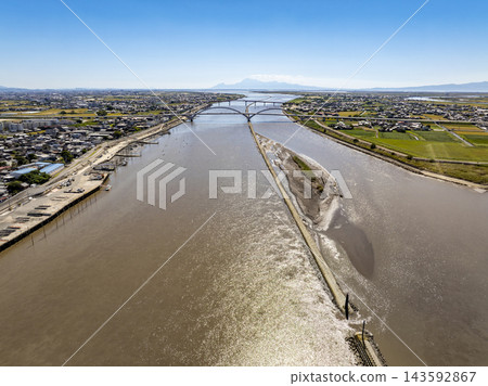 A drone aerial photograph taken from above the Chikugo River, showing the mouth of the Chikugo River, the Ariake Chikugo River Bridge, the Nitta Bridge, and Mount Unzen. A drone aerial photograph taken from above the Chikugo River, showing the mouth of the Chikugo River, the Ariake Chikugo River Bridge, the Nitta Bridge, and Mount Unzen. 143592867