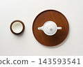 An overhead view of a teapot, teacups, and tray. 143593541