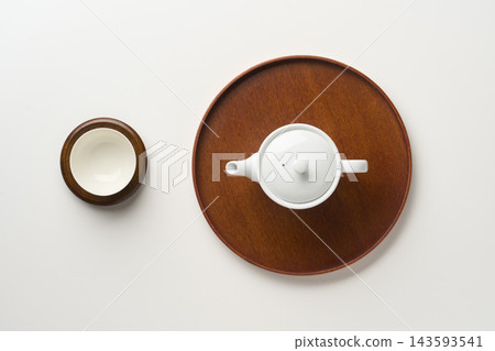 An overhead view of a teapot, teacups, and tray. An overhead view of a teapot, teacups, and tray. 143593541