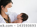 Asian doctor holding cute newborn baby in her arms for physical check up in clinic. 143593693