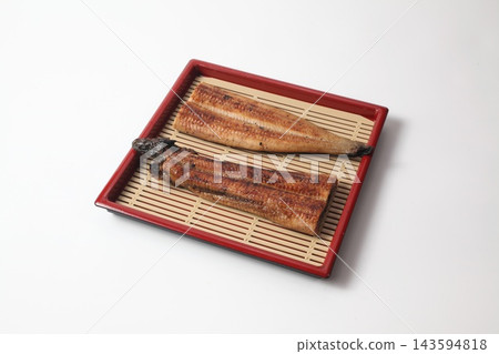 Grilled eel cut in half and arranged on a bamboo mat. Grilled eel cut in half and arranged on a bamboo mat. 143594818