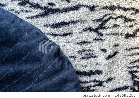 Close look at a round cushion and patterned rug laid on a floor Close look at a round cushion and patterned rug laid on a floor 143595293