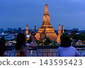 Bangkok, Thailand - June 11, 2025: Evening view of tourists watching the sunset along the Chao Phraya River at Wat Arun. 143595423