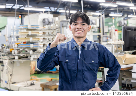 在製造工廠裡,年輕的外籍勞工帶著微笑,豎起大拇指——外國人才在日本製造業蓬勃發展 在製造工廠裡,年輕的外籍勞工帶著微笑,豎起大拇指——外國人才在日本製造業蓬勃發展 143595654