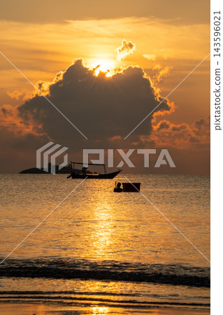 Captivating golden hour sunset over tranquil ocean waters. Sun rays pierce through clouds, illuminating a silhouetted fishing boat and a person. A tropical island adds to this serene seascape. Captivating golden hour sunset over tranquil ocean waters. Sun rays pierce through clouds, illuminating a silhouetted fishing boat and a person. A tropical island adds to this serene seascape. 143596021