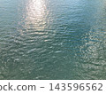 A greenish water surface reflecting the setting sun (horizontal) 143596562