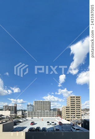 A cityscape with a clear blue sky and rows of apartment buildings. 143597005