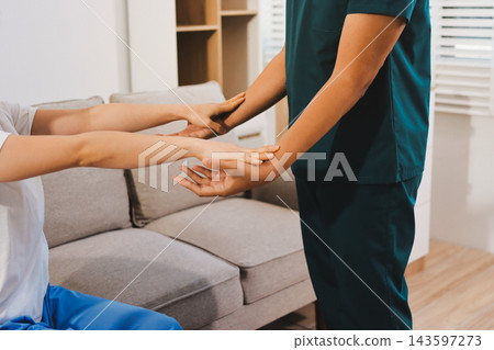 Healthcare professional assisting patient with arm exercise Healthcare professional assisting patient with arm exercise 143597273
