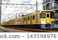 A yellow train, the New 2000 series express bound for Seibu Shinjuku, running between Iruma and Shin-Tokorozawa on the Seibu Shinjuku Line. 143598976