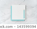 Top view of blank white and blue square greeting card with pencil mockup on marble background with copy space 143599394