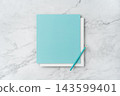 Top view of blank white and blue square greeting card with pencil mockup on marble background with copy space 143599401