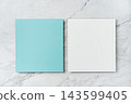 Top view of blank blue and white square greeting card mockup on marble background with copy space 143599405