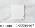 Top view of blank white square greeting card with pencil mockup on marble background with copy space 143599407