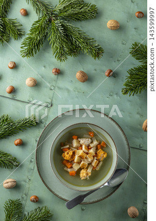 Hot chicken soup with vegetables and croutons on holiday table Hot chicken soup with vegetables and croutons on holiday table 143599997