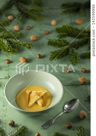 Pumpkin soup with croutons, nuts and fir branches Pumpkin soup with croutons, nuts and fir branches 143599998