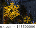 Glowing snowflake lights decorating a festive Christmas market 143600000