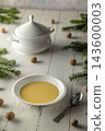 Creamy pumpkin soup on a rustic winter table 143600003