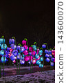 Colorful glowing flower lanterns illuminating a winter garden 143600070