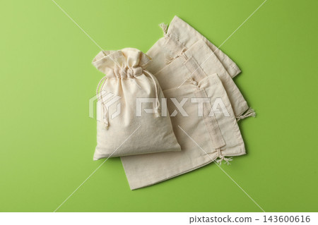 Cotton eco bags on light green background, flat lay Cotton eco bags on light green background, flat lay 143600616