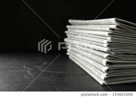Stack of newspapers on dark stone table, space for text. Journalist's work Stack of newspapers on dark stone table, space for text. Journalist's work 143601009