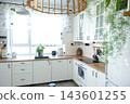 Bright corner of a scandinavian kitchen with hanging utensils on a rail and potted plants, home design, cozy lifestyle. 143601255
