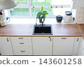 Minimalist white kitchen counters with integrated black sink placed directly under a large window, home design, cozy lifestyle. 143601258