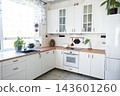 Cozy white scandinavian kitchen with glass front cabinets wooden textures and lively green plants, home design, cozy lifestyle. 143601260
