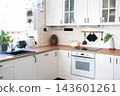 Bright clean white kitchen with rail for utensils wooden worktop and built in stainless steel oven, home design, cozy lifestyle. 143601261