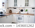 Corner view of a stylish white scandinavian kitchen showcasing wooden details rail and ceramic decorations, home design, cozy lifestyle. 143601262