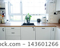 Symmetrical shot of a white kitchen lower cabinets with wooden countertop and integrated oven and sink, home design, cozy lifestyle. 143601266