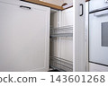 Installation of a vertical pull out cargo wire basket inside a white kitchen cabinet, furniture assembly, kitchen installation. 143601268