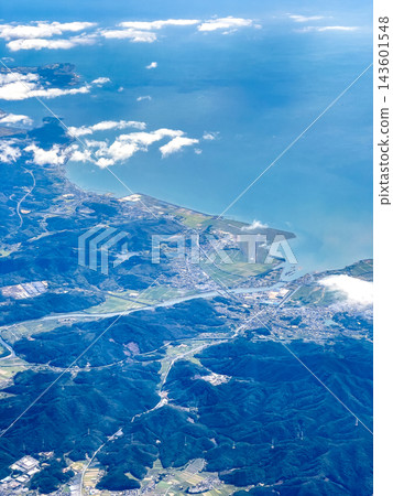從飛機舷窗看到的鳥瞰圖:蔚藍的大海、綿延的海岸線和巍峨的山脈,景色優美。 從飛機舷窗看到的鳥瞰圖:蔚藍的大海、綿延的海岸線和巍峨的山脈,景色優美。 143601548