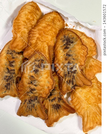 Crispy and golden mini bungeoppang with a soft, fluffy filling of sweet red bean or custard. A delightful bite-sized Korean fish-shaped pastry, perfect for a warm and nostalgic treat! 143601572