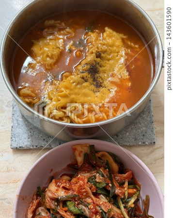 Steaming hot ramyun with rich, savory broth and chewy noodles, paired with spicy, tangy kimchi. A perfect Korean comfort food combination, balancing bold flavors and satisfying textures. Steaming hot ramyun with rich, savory broth and chewy noodles, paired with spicy, tangy kimchi. A perfect Korean comfort food combination, balancing bold flavors and satisfying textures. 143601590