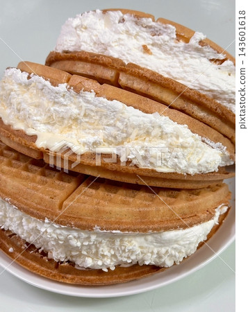 Crispy, golden waffles topped with creamy ice cream, creating a perfect balance of warm and cold, crunchy and smooth. A delightful dessert or breakfast treat, with toppings like fruits or syrup. Crispy, golden waffles topped with creamy ice cream, creating a perfect balance of warm and cold, crunchy and smooth. A delightful dessert or breakfast treat, with toppings like fruits or syrup. 143601618