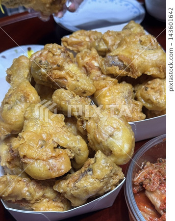 Crispy Korean fried chicken, perfectly glazed with a sweet and spicy sauce. Ideal for food photography and menus, showcasing the irresistible crunch and flavor of this beloved dish. 143601642