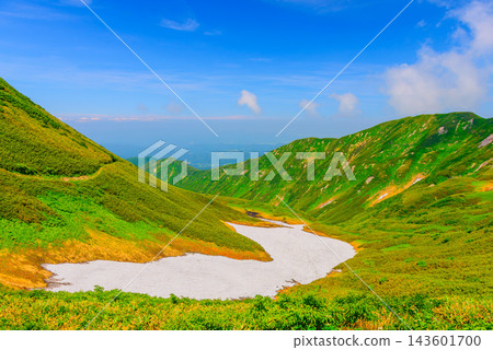 夏季攀登月山,從宇笠嶽山脊小徑上拍攝到美麗的雪山斜坡和下方延伸的山谷細節。 夏季攀登月山,從宇笠嶽山脊小徑上拍攝到美麗的雪山斜坡和下方延伸的山谷細節。 143601700