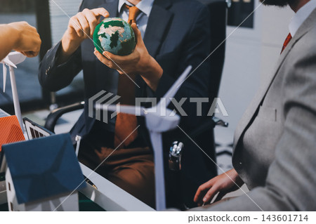 Team presenting a solar and wind energy project with model house, earth globe and green ideas in an office meeting Team presenting a solar and wind energy project with model house, earth globe and green ideas in an office meeting 143601714