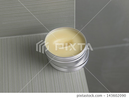 Open body butter metal tin in green bathroom. Handmade Herbal cosmetic product for home use 143602090