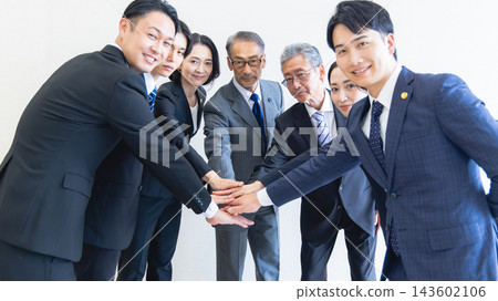 由七名男女組成的商務團隊,面帶微笑,手牽著手,團結一致。 由七名男女組成的商務團隊,面帶微笑,手牽著手,團結一致。 143602106